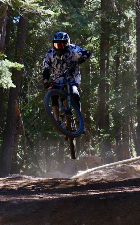 Brian mid-air on a mountain bike trail.